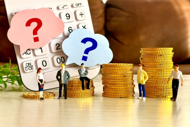 Miniature people stand by stacked coins and a calculator with pink and blue question-mark clouds, signaling money uncertainty.